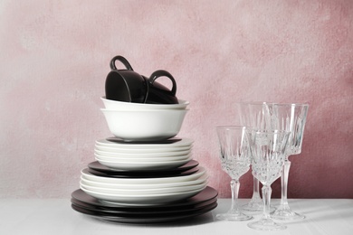Photo of Set of dinnerware on table against color background. Interior element