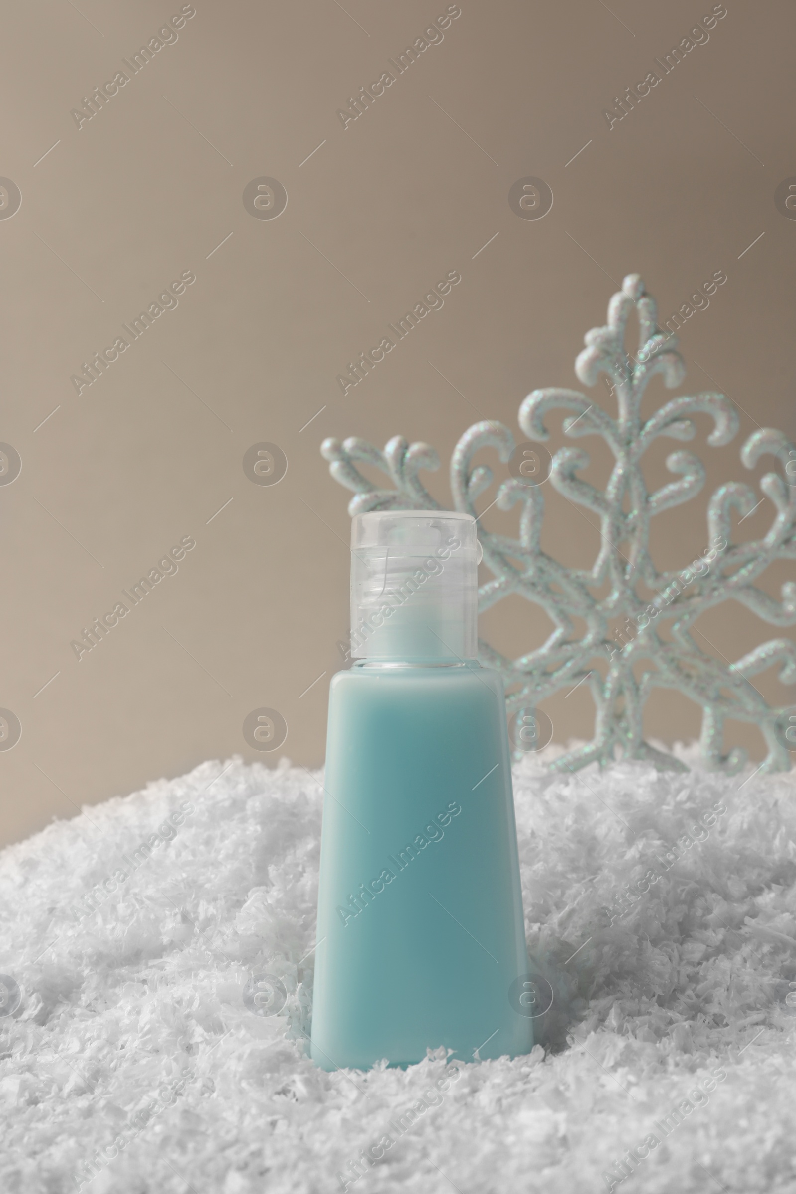 Winter skin care. Stylish presentation of cosmetic product on artificial snow against light grey background Photo of Winter skin care. Stylish presentation of cosmetic product on artificial snow against light grey background