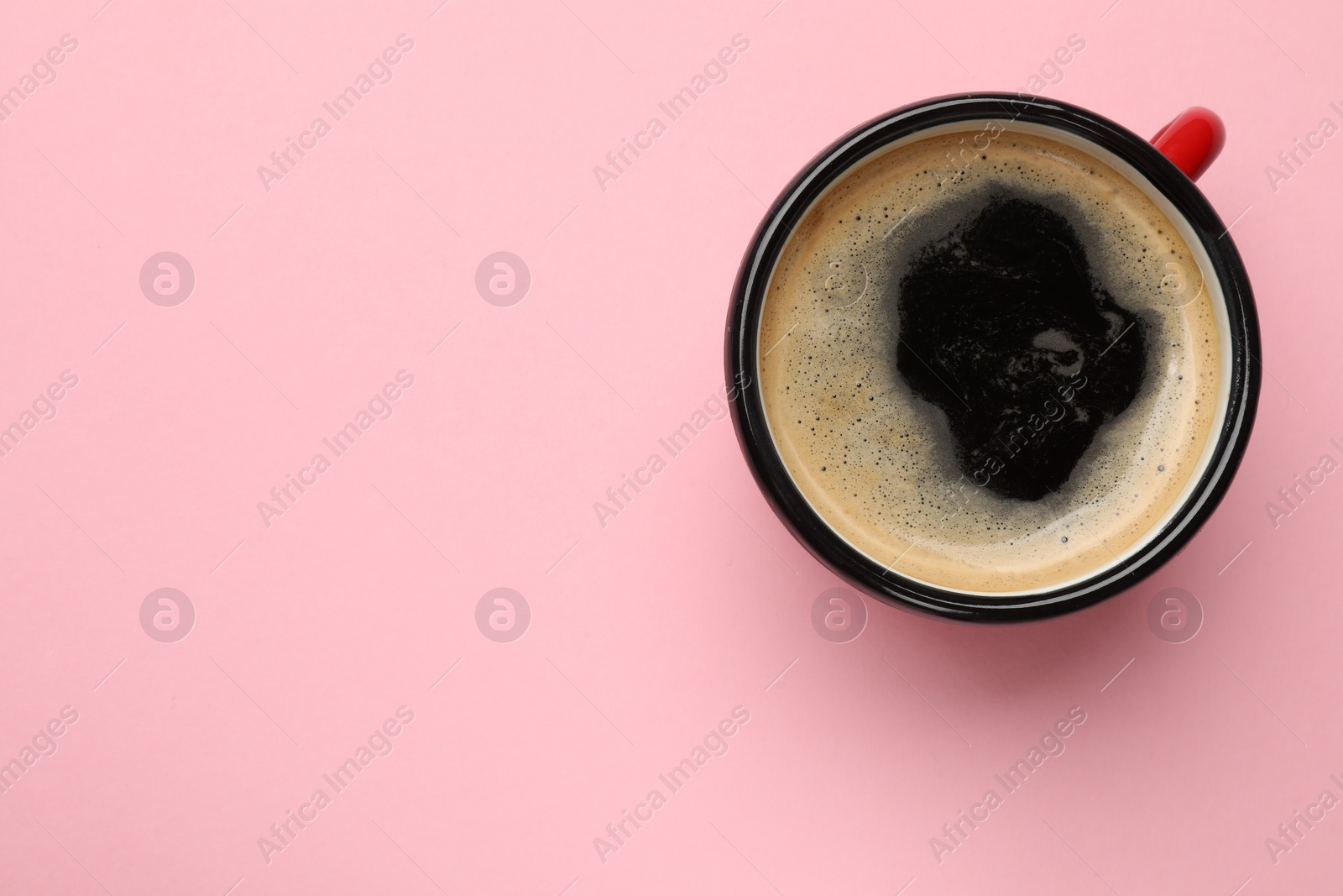 Photo of Fresh coffee in cup on pink background, top view. Space for text