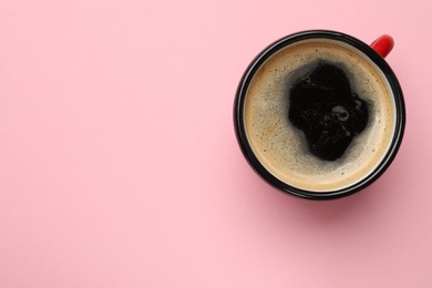 Fresh coffee in cup on pink background, top view. Space for text