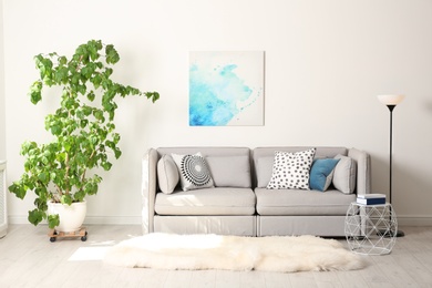 Photo of Stylish room interior with large houseplant and couch