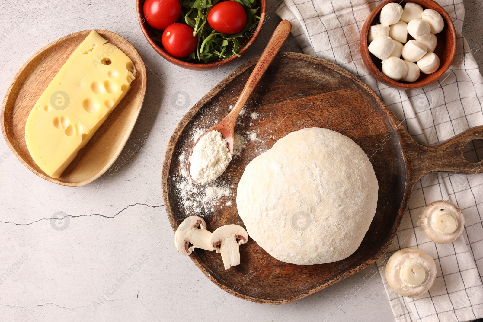 Photo of Pizza dough and products on gray textured table, flat lay