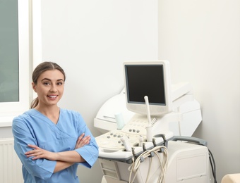 Professional sonographer near modern ultrasound machine in clinic