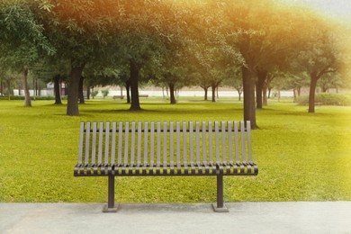 Photo of Stylish metal bench in park on sunny day
