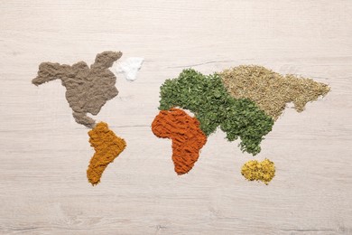 Photo of World map of different spices on wooden table, flat lay