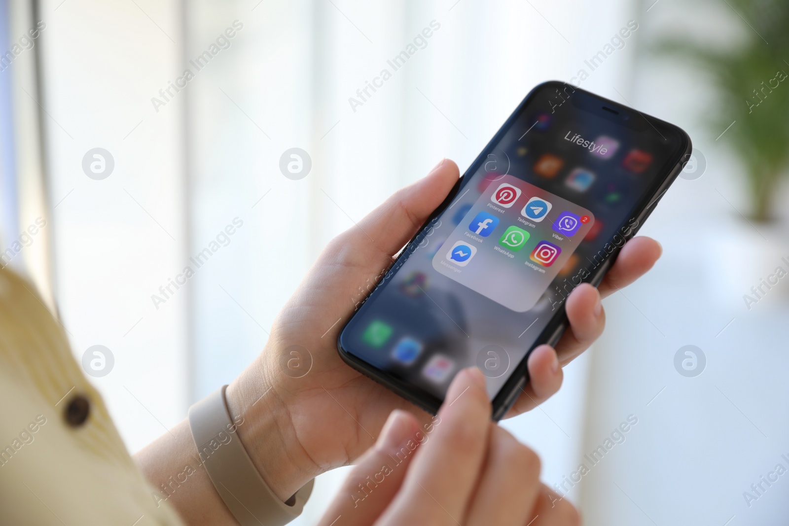 Photo of MYKOLAIV, UKRAINE - MARCH 16, 2020: Woman holding iPhone 11 with social media icons on screen indoors, closeup