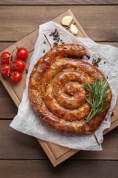 Photo of Delicious homemade sausage with spices and tomatoes on wooden table, top view