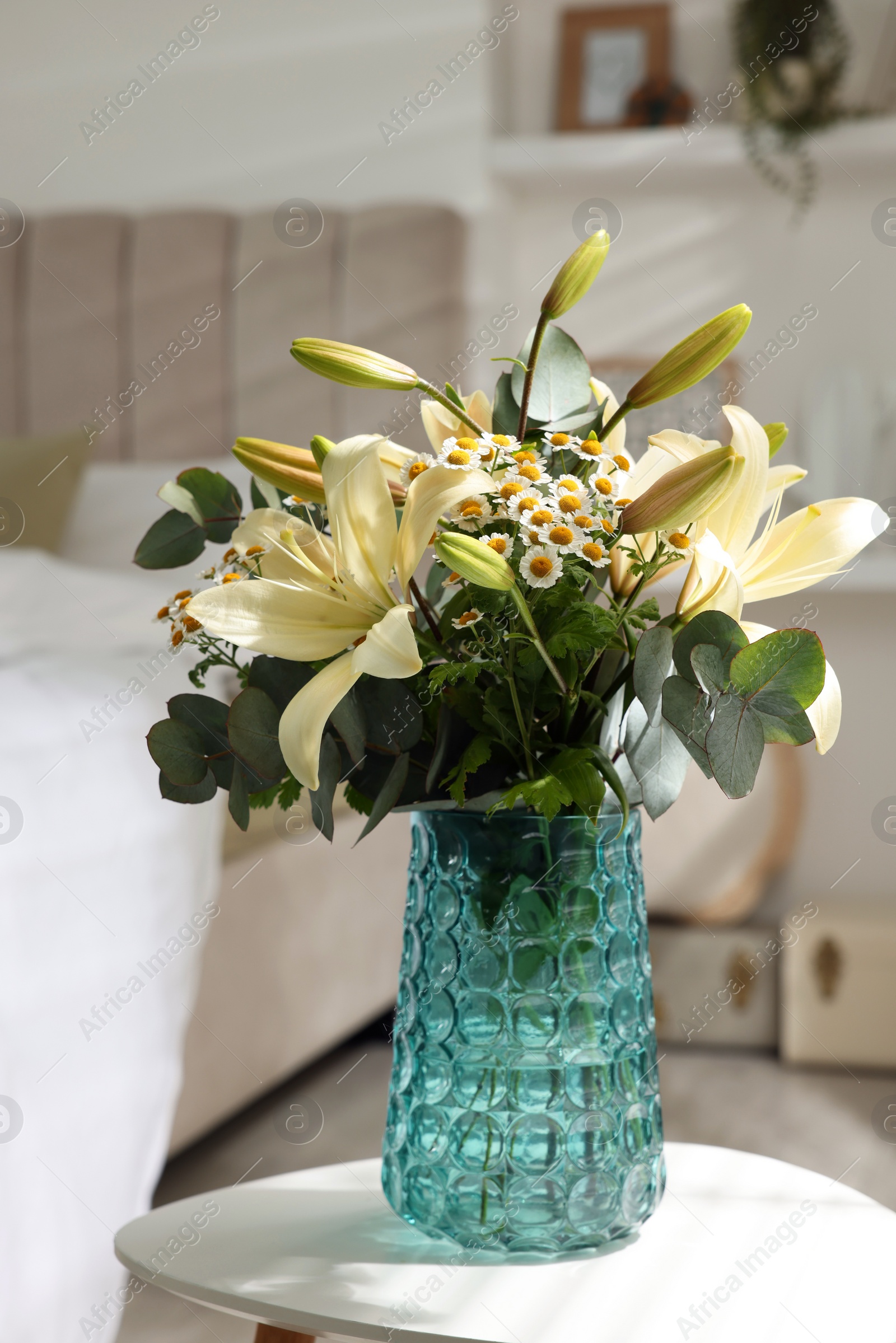 Photo of Bouquet of beautiful flowers on white table in bedroom