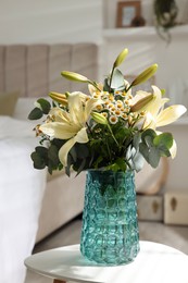 Photo of Bouquet of beautiful flowers on white table in bedroom