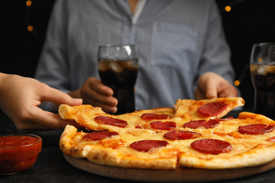 Photo of Women taking tasty pepperoni pizza at table, closeup