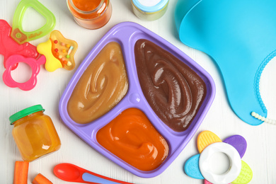 Photo of Flat lay composition with healthy baby food and accessories on white wooden table