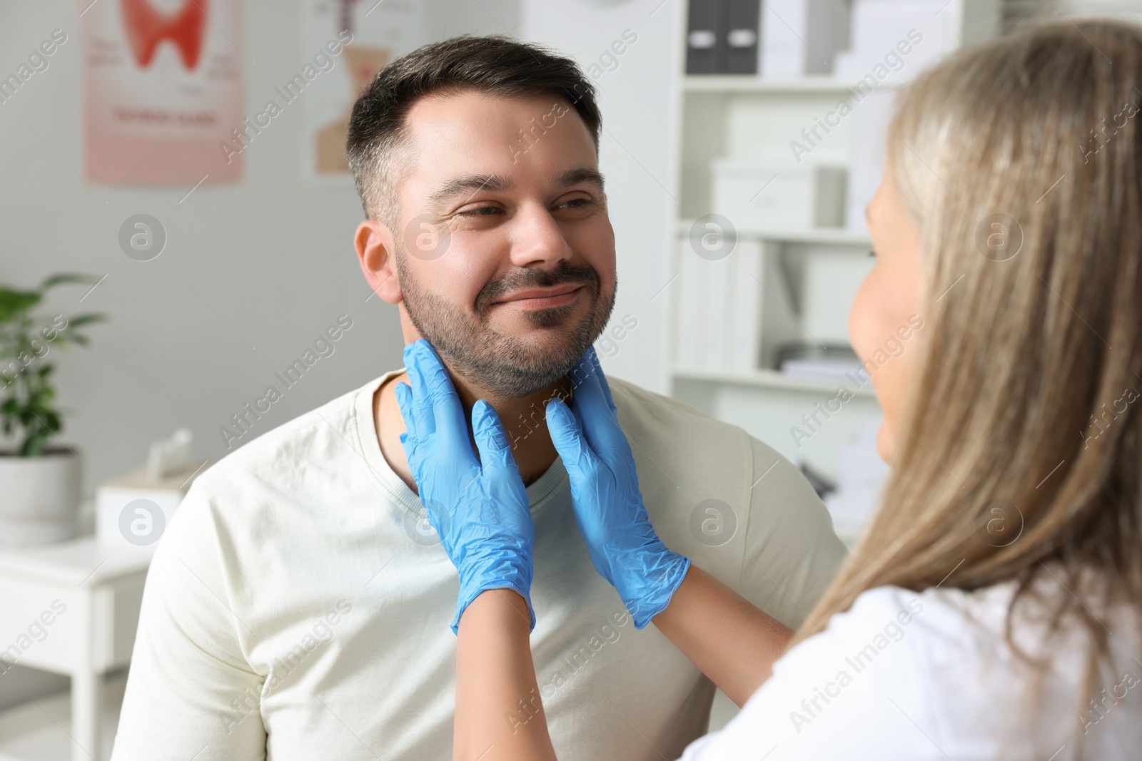 Photo of Endocrinologist examining thyroid gland of patient at hospital