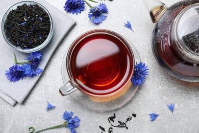 Flat lay composition with tea and cornflowers on light table