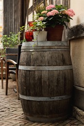 Photo of Traditional wooden barrel and beautiful houseplants outdoors