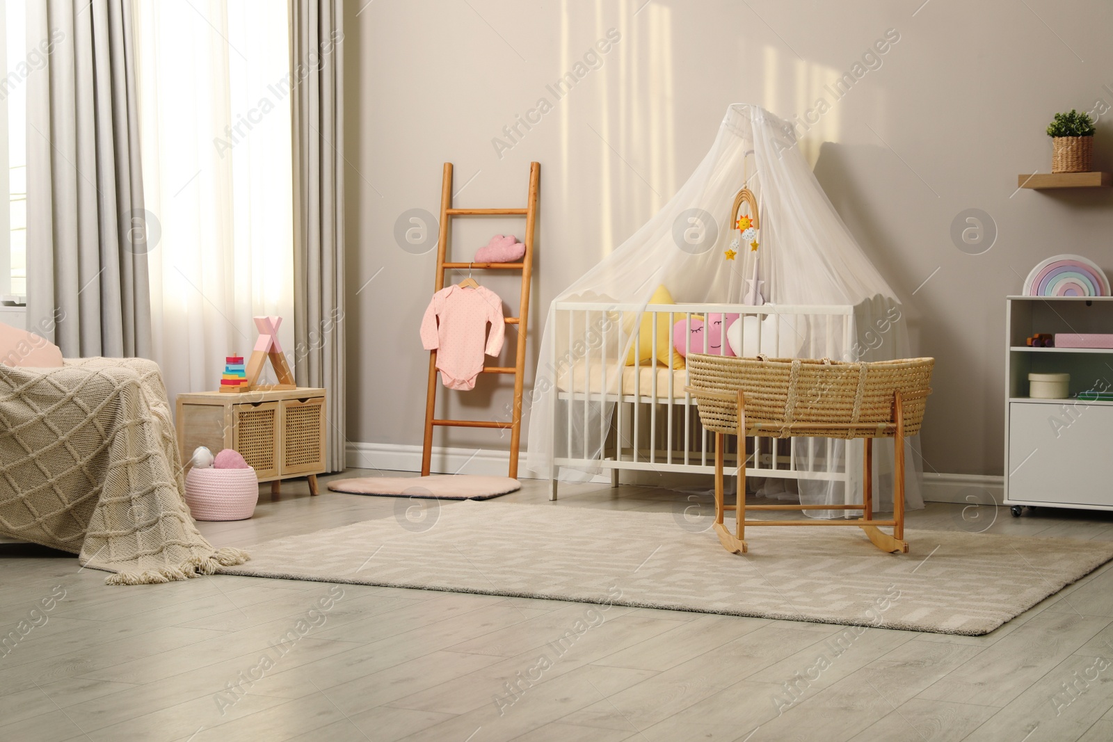 Photo of Cozy baby room with crib and other furniture. Interior design