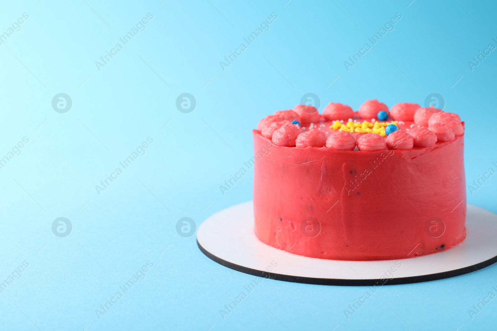 Photo of Cute bento cake with tasty cream on light blue background, space for text