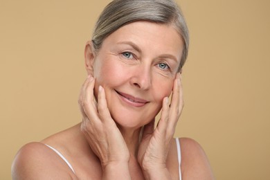 Portrait of senior woman with aging skin on beige background. Rejuvenation treatment