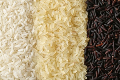 Photo of Brown and other types of rice as background, closeup