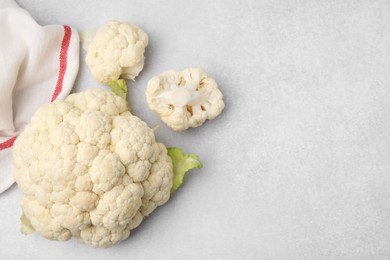 Cut fresh raw cauliflower on light grey table, flat lay. Space for text