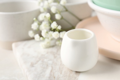 Photo of Different dishware and marble board on table, space for text