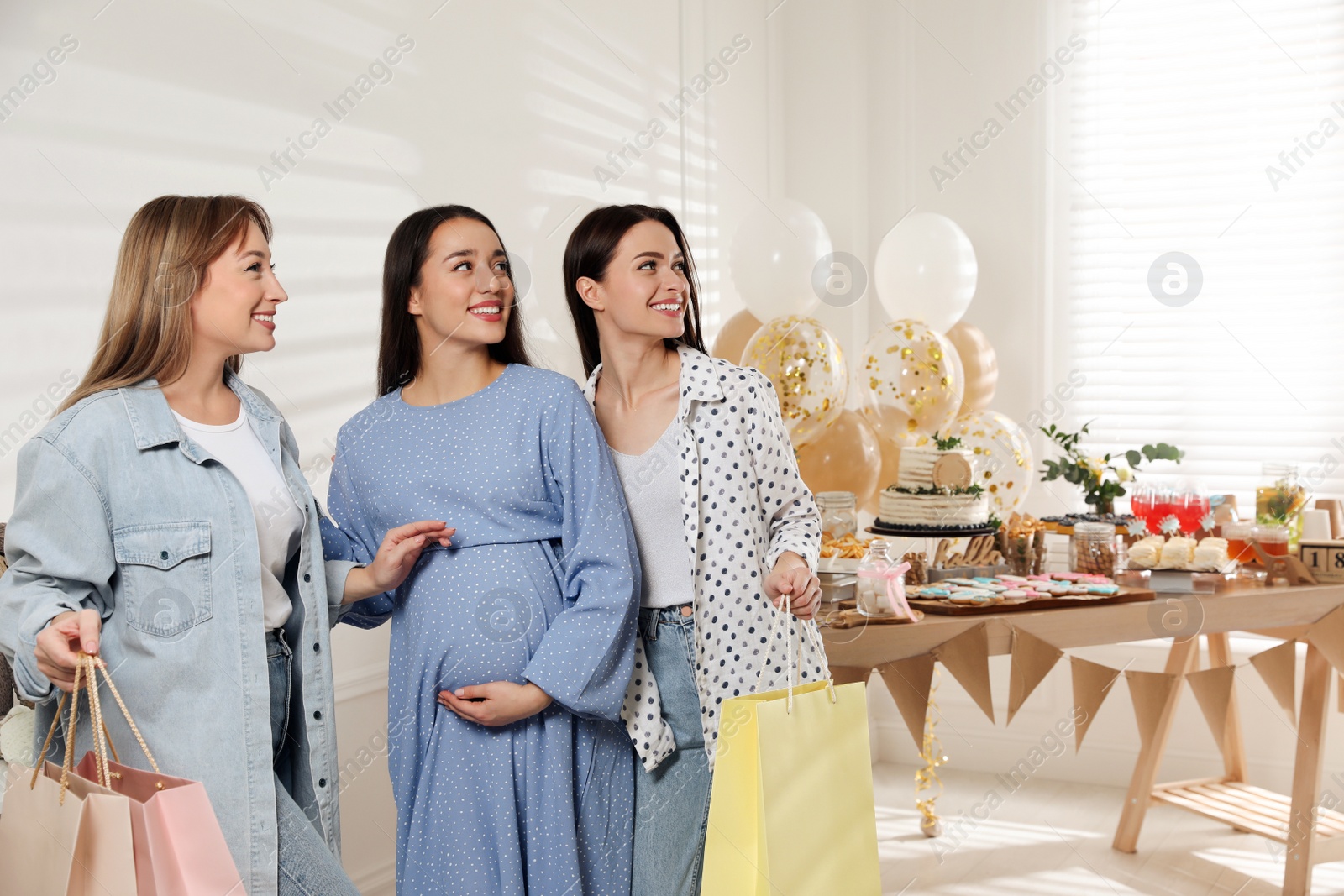 Photo of Happy pregnant woman spending time with friends at baby shower party