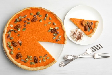 Photo of Delicious homemade pumpkin pie on white wooden table, flat lay