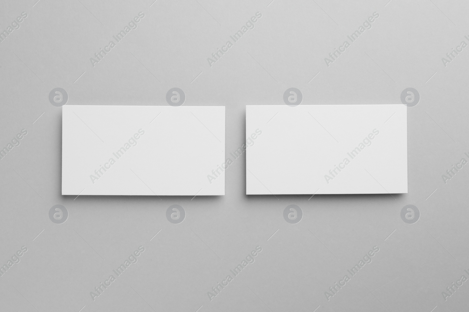 Photo of Blank business cards on light gray background, top view. Mockup for design