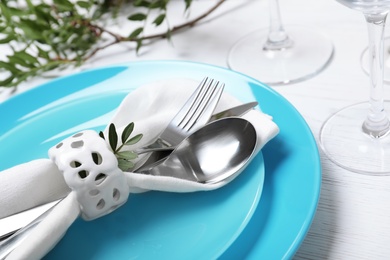 Festive table setting with plates, cutlery and napkin on wooden background, closeup