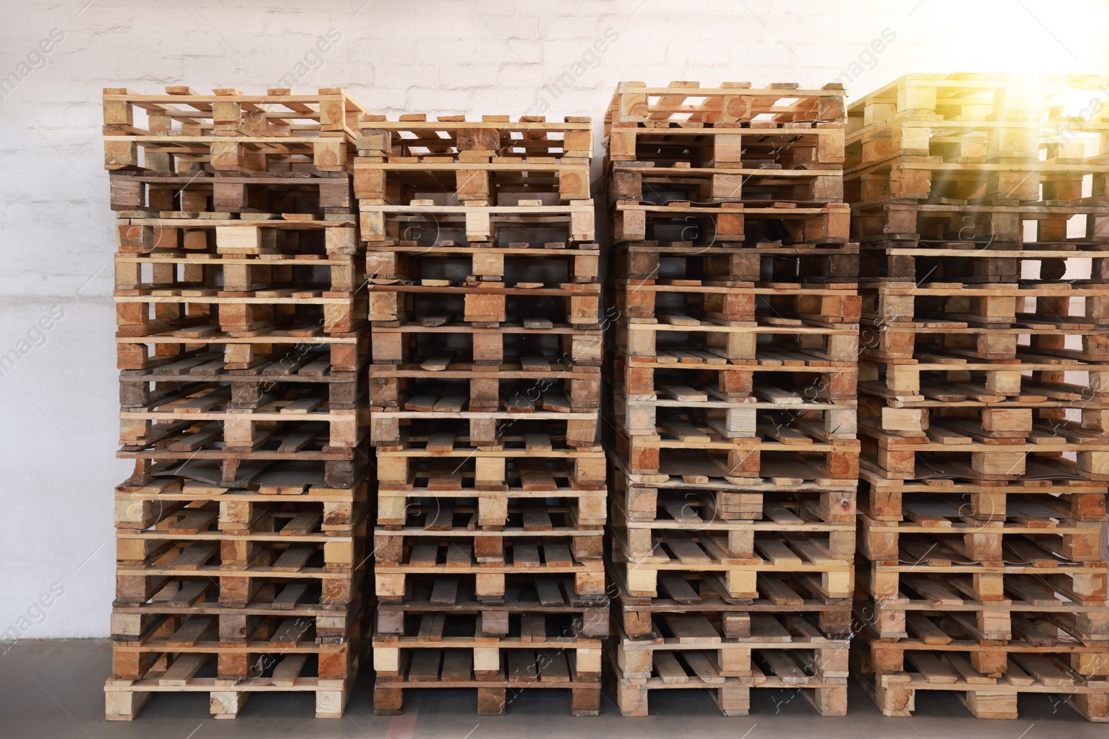 Image of Many empty wooden pallets stacked in warehouse