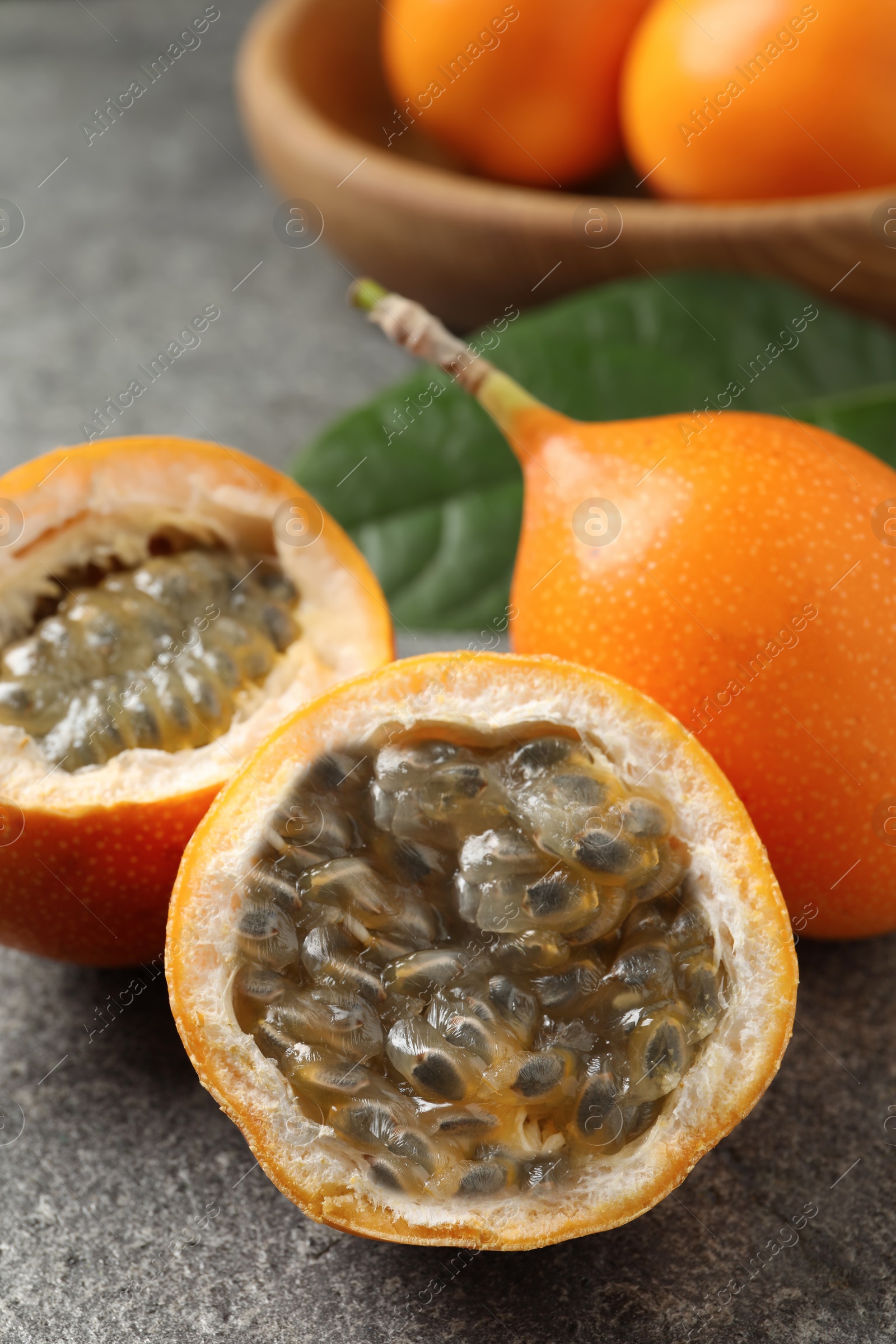 Photo of Delicious ripe granadillas on grey table, closeup