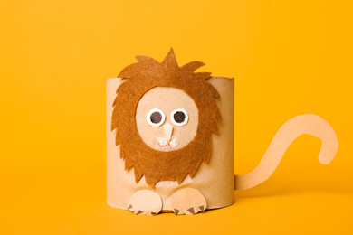 Photo of Toy lion made of toilet paper roll on yellow background