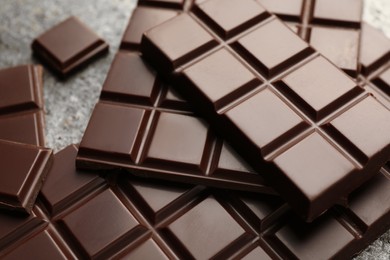 Photo of Delicious dark chocolate on grey table, closeup