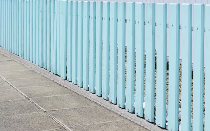 Photo of Wooden fence on sunny day near building outdoors