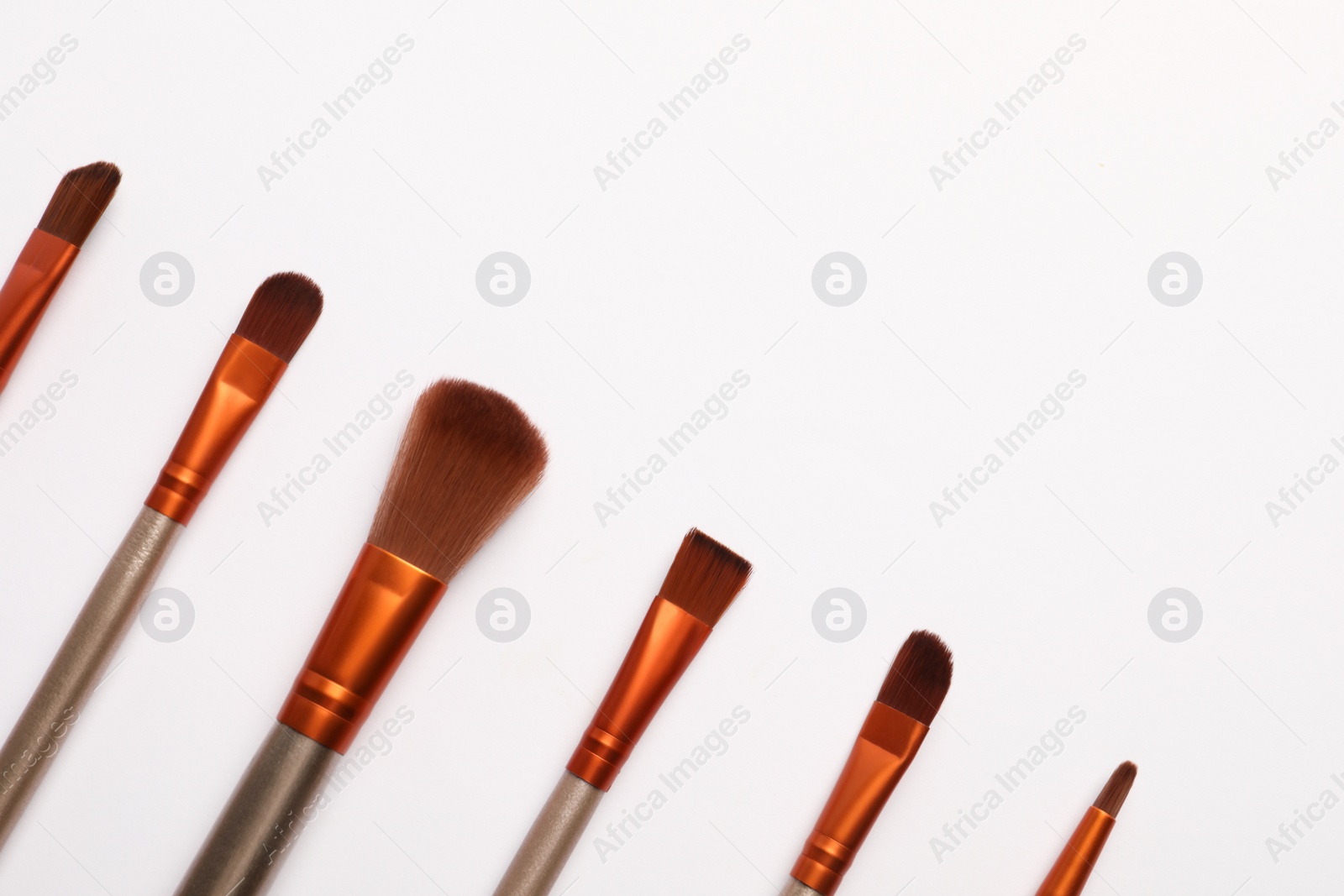 Photo of Set of makeup brushes on white background, flat lay. Space for text