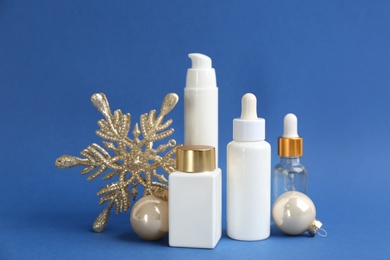 Beautiful composition with cosmetic products on blue background. Winter care