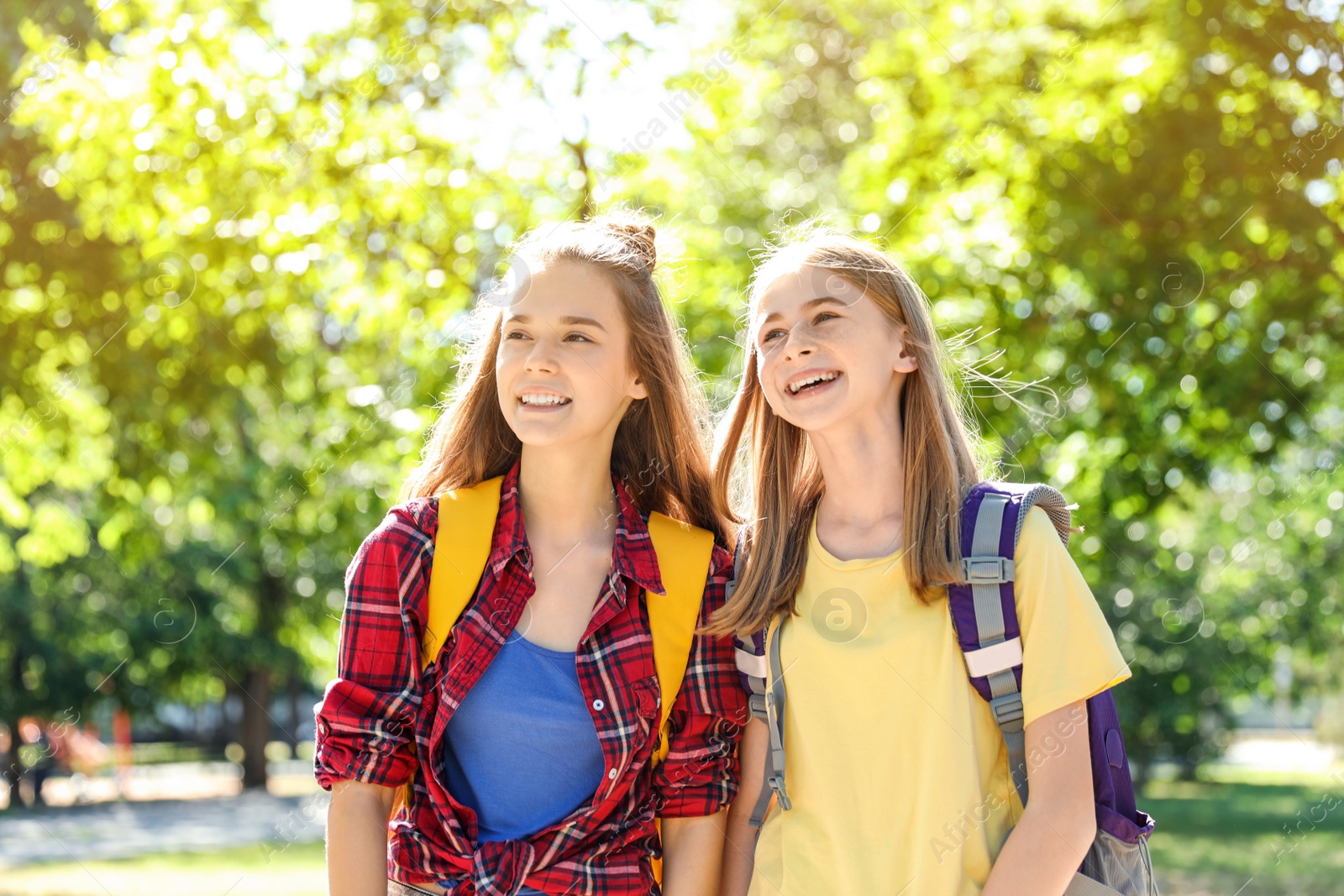 Photo of Girls with backpacks outdoors on sunny day. Summer camp