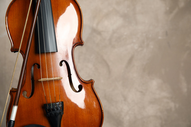 Classic violin and bow on beige background, closeup. Space for text