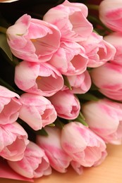 Beautiful bouquet of fresh pink tulips on table, closeup