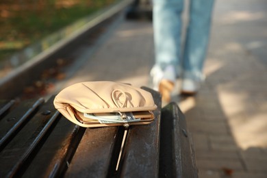 Woman lost her purse on wooden surface outdoors, selective focus