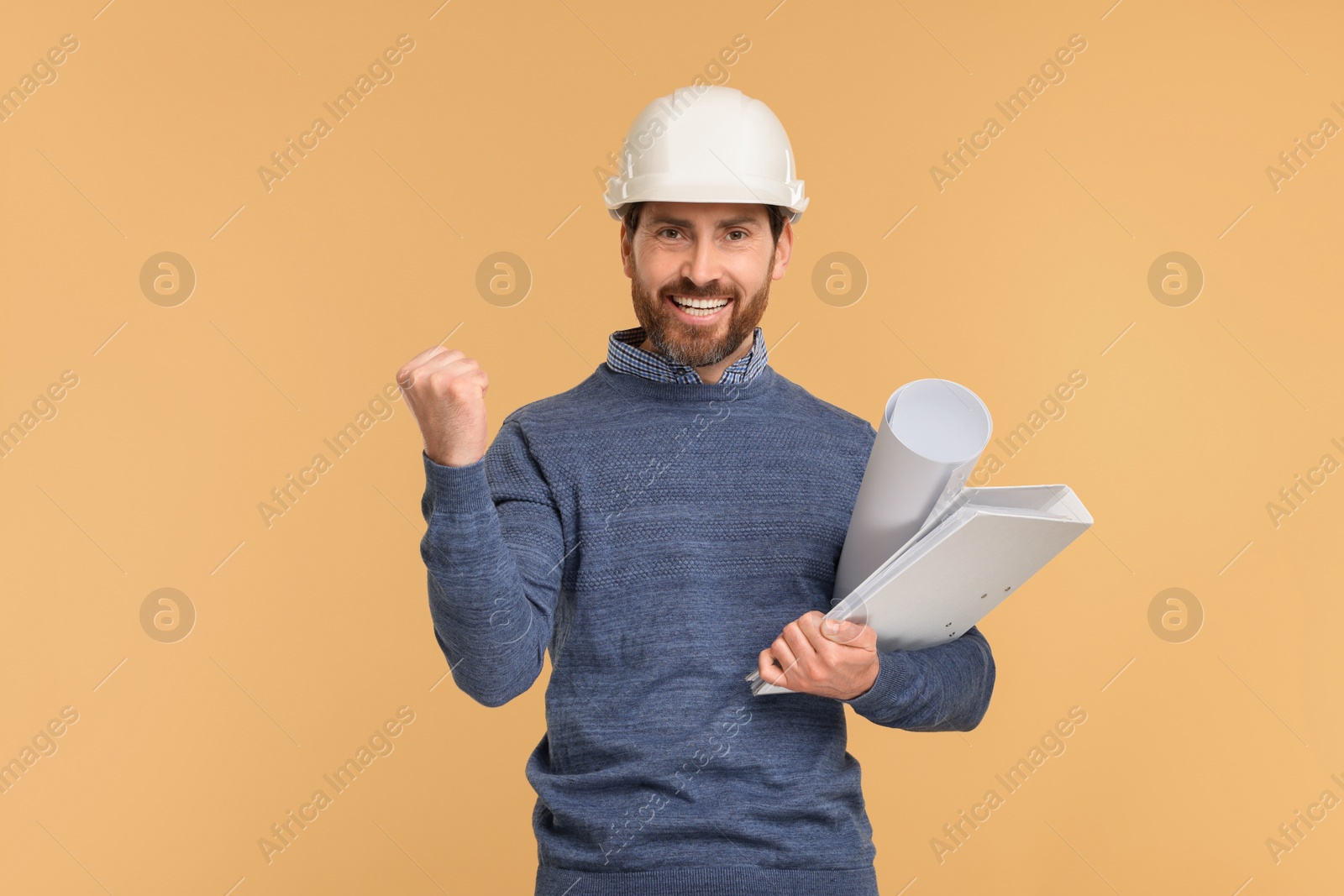 Photo of Architect in hard hat with draft and folder on beige background