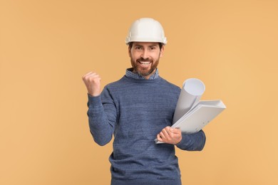 Architect in hard hat with draft and folder on beige background