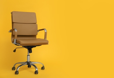 Modern office chair on yellow background. Space for text