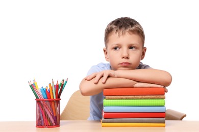 Little boy with stationery and stack of books suffering from dyslexia at wooden table
