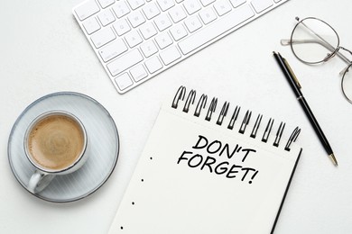 Image of Reminder DON'T FORGET written in notebook on white table, flat lay 