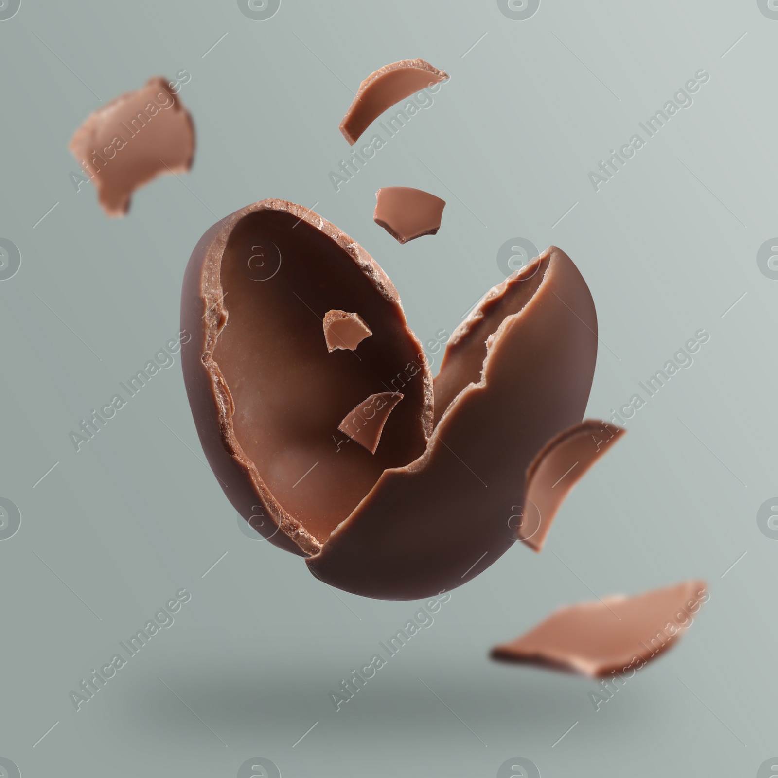 Image of Exploded milk chocolate egg on grey background