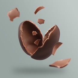 Exploded milk chocolate egg on grey background