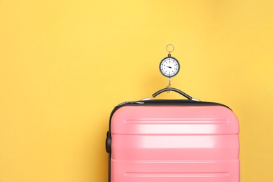 Photo of Modern suitcase and hanging scales against color background, space for text