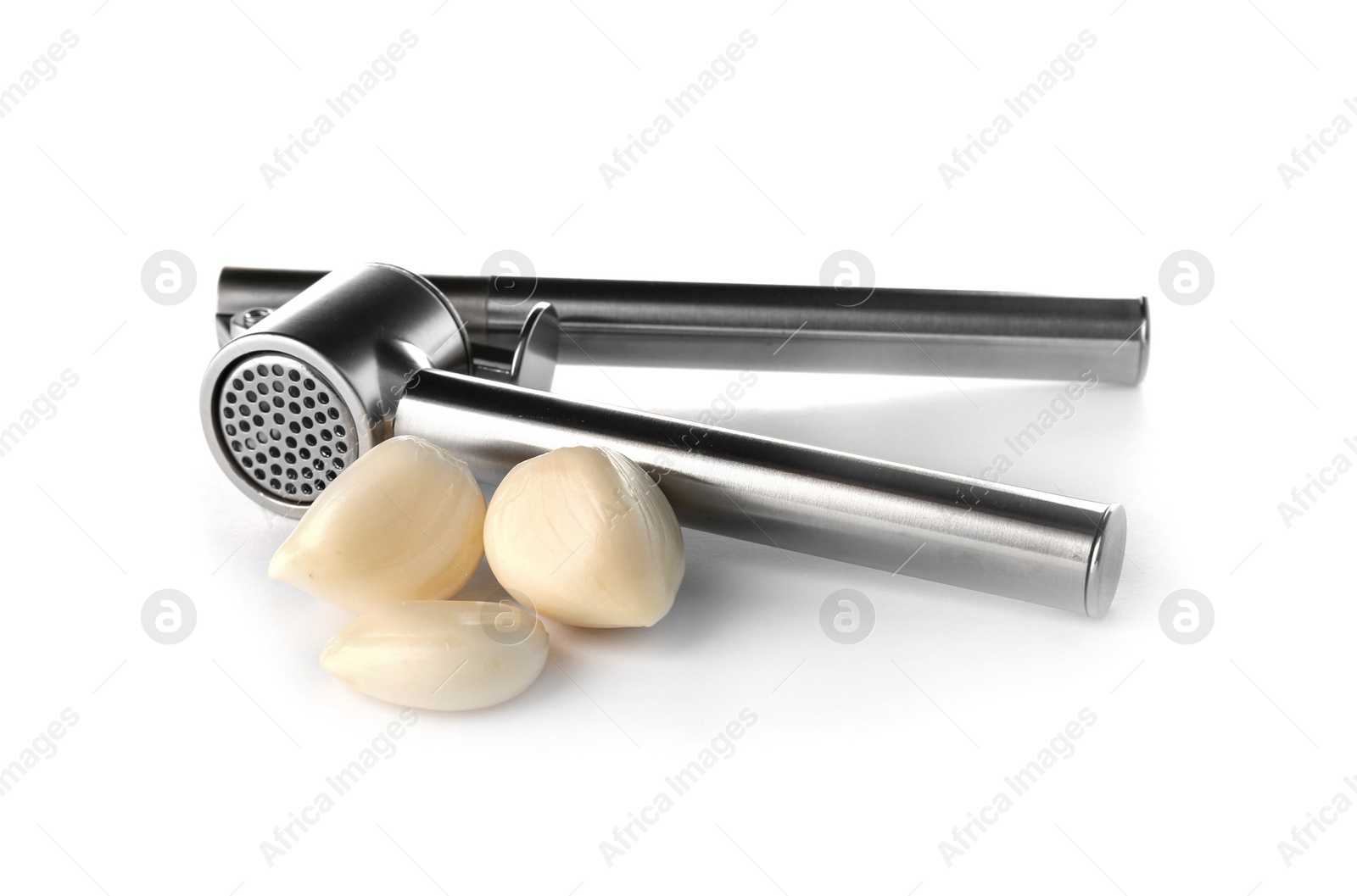 Photo of Garlic press and cloves on white background. Kitchen utensil