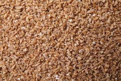 Dry wheat groats as background, top view