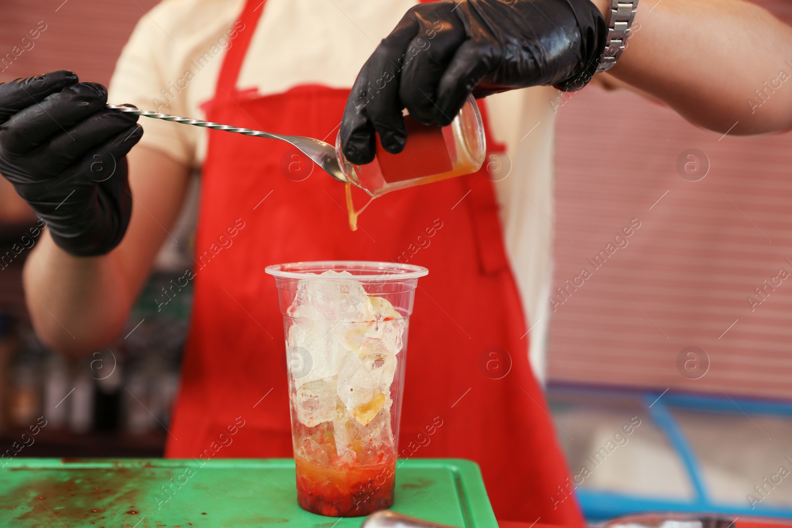 Photo of Male bartender preparing refreshing drink at table, closeup